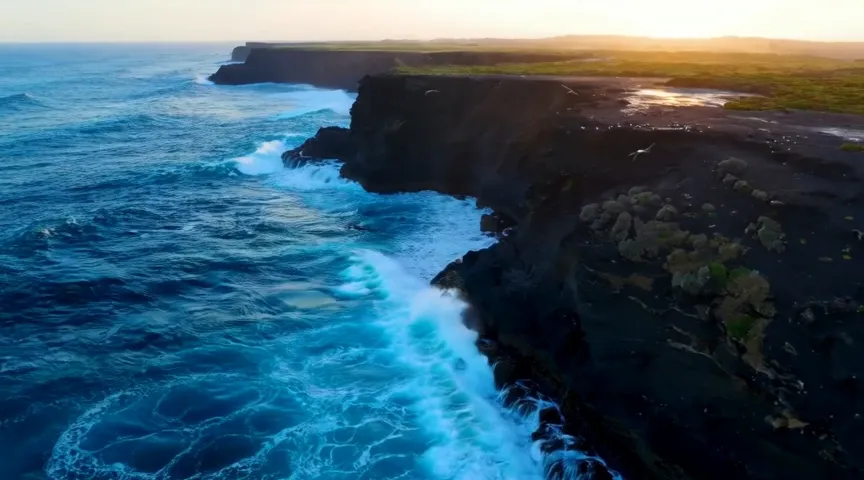 Kandinsky 6.0 Pro video: a drone shot over waves and black cliffs at golden hour